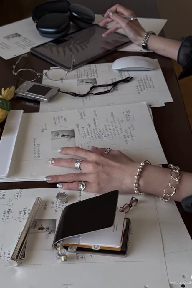 A creative desk with notes, headphones and a journal